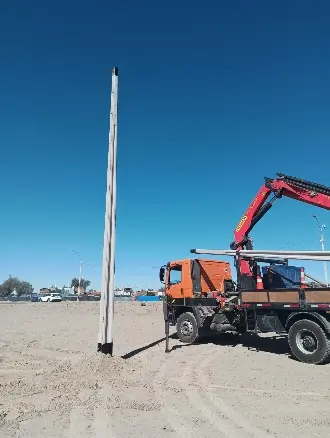Poste de alumbrado público instalado en estacionamiento.